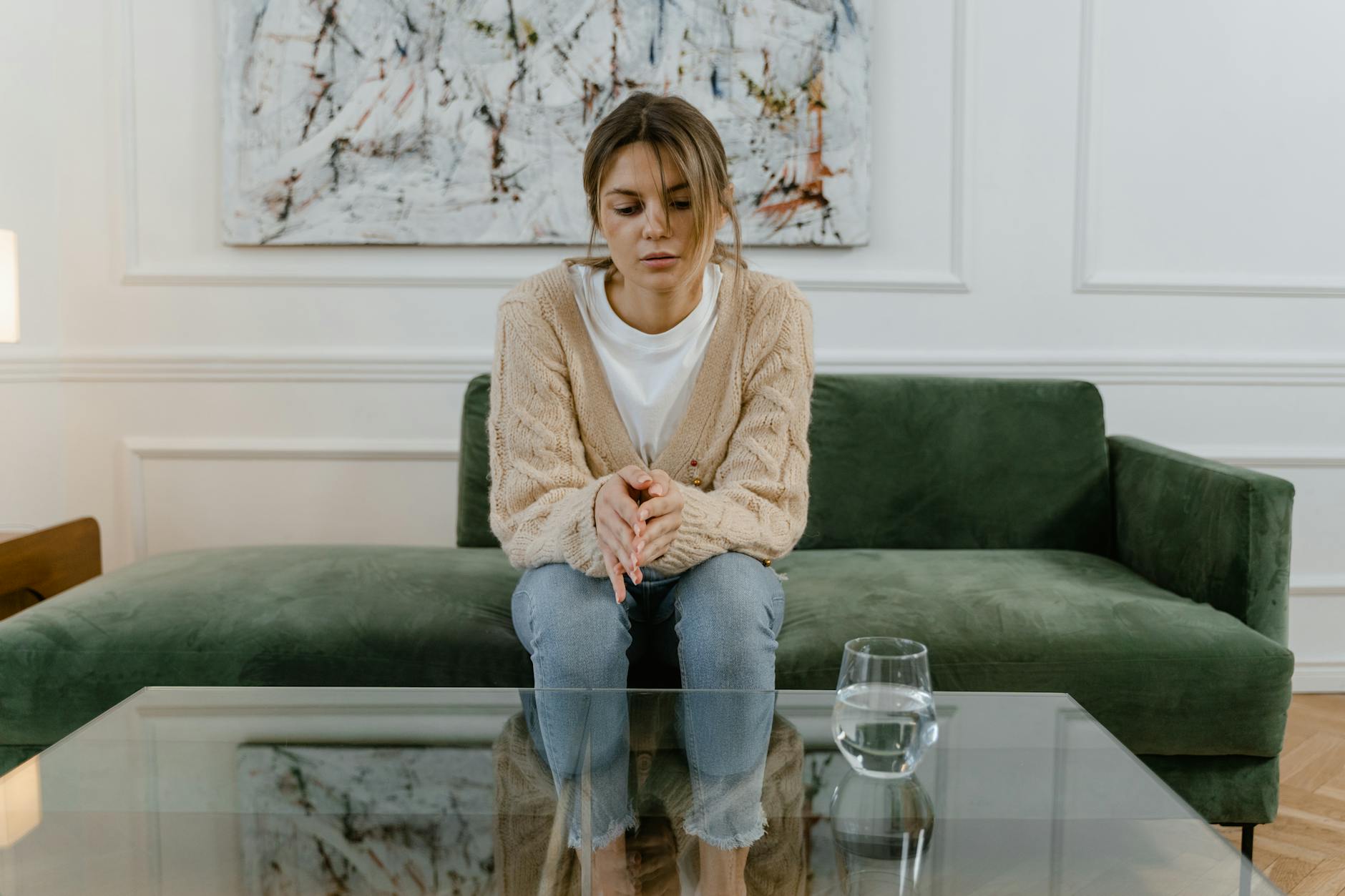 a sad woman sitting on a sofa