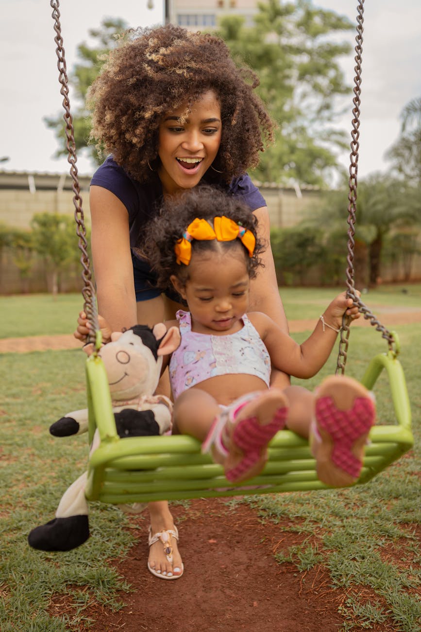 girl in white tank top sitting on swing. family portrait article.