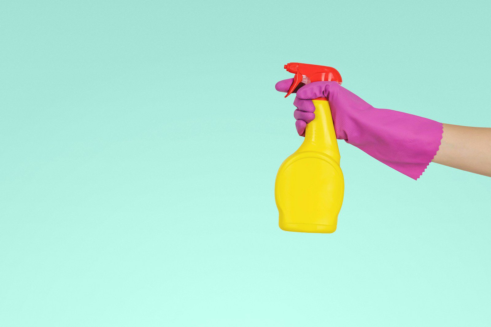 person holding yellow plastic spray bottle - article house cleaning services