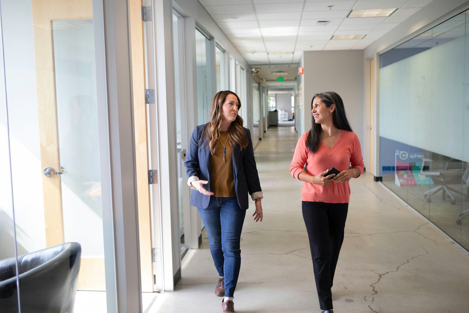 2 women standing near white wall. businss opportunities in crisis article