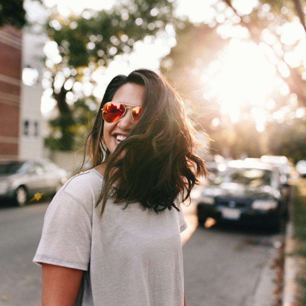 Perimenopause: Symptoms, Hot Flashes, and What Every Woman Needs to Know 1 woman wearing white T-shirt smiling. perimenopause and hot flashes.
